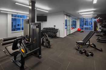 A gym with cardio equipment and weights in a building